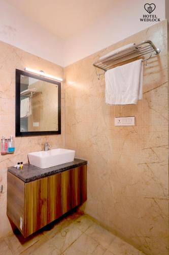 a bathroom with a sink and a mirror at Hotel Wedlock in Gurgaon