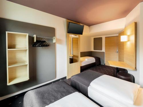 a small room with a bed and a bathroom at B&B Hotel Mönchengladbach in Mönchengladbach