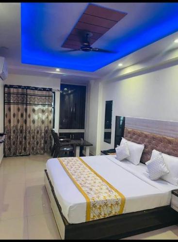a bedroom with a large bed with a blue ceiling at Hotel Tavish Near IGI Airport in New Delhi
