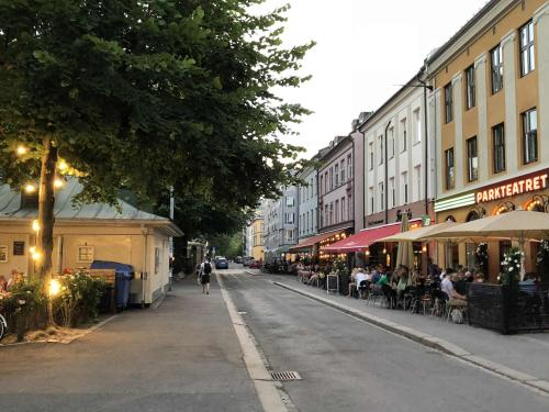 a person walking down a street with tables and chairs at Stylish Grünerløkka penthouse with rooftop terrace in Oslo