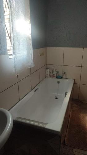 a white bath tub in a bathroom with a window at Di-Koena cottage in Springs
