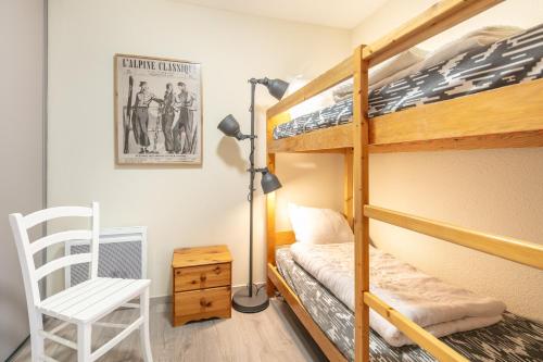 1 Schlafzimmer mit 2 Etagenbetten und einem Stuhl in der Unterkunft L'Alpine Classique - Station de Ski à pied in Chamrousse