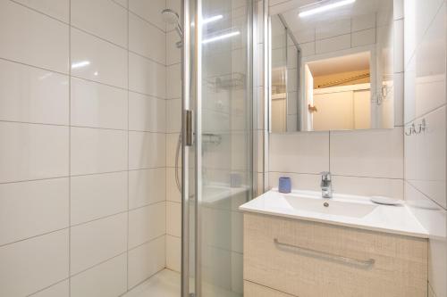 ein weißes Badezimmer mit Waschbecken und Dusche in der Unterkunft L'Alpine Classique - Station de Ski à pied in Chamrousse