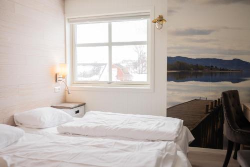 a bedroom with two beds in front of a window at Mefjord Brygge in Mefjordvær