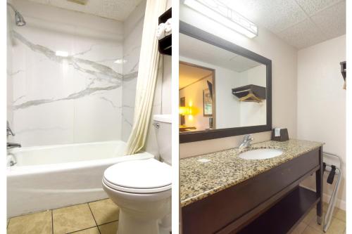a bathroom with a toilet and a sink and a mirror at Tennessee Mountain Lodge Riverside by OYO in Pigeon Forge