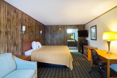 a hotel room with a bed and a desk at Tennessee Mountain Lodge Riverside by OYO in Pigeon Forge