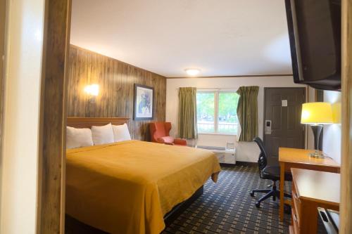 a hotel room with a bed and a desk at Tennessee Mountain Lodge Riverside by OYO in Pigeon Forge