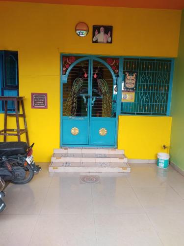 a room with a blue door and a yellow wall at Arunachala Home Stay - Closest to Temple in Tiruvannāmalai