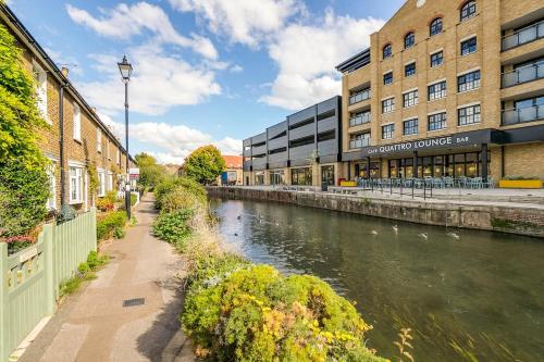 a river in front of a building next to a building at Riverside Cottage Retreat Hertford Town Sleeps 6 in Hertford