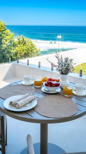 a table with food and a view of the beach at Salt and Sand in Wilderness