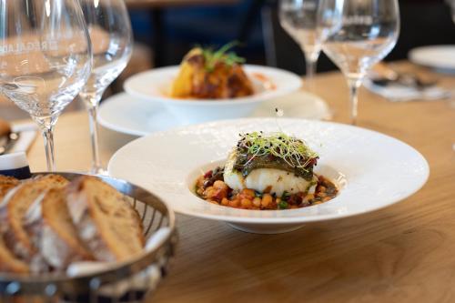 a table with plates of food and glasses of wine at Hôtel de France - Beaune in Beaune