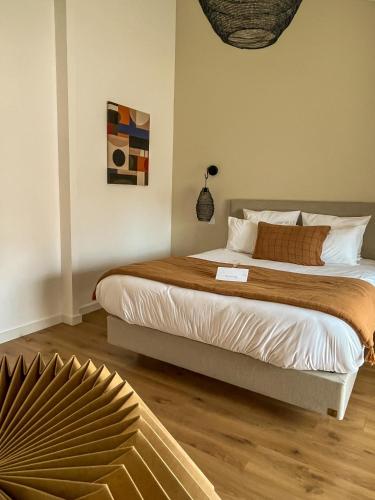 a bedroom with a large bed with a wooden floor at Le Chai in Nissan-lez-Enserune
