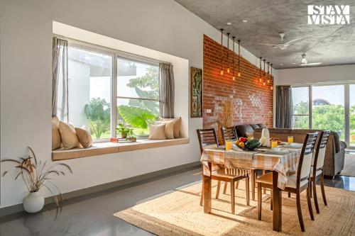 a kitchen and dining room with a table and chairs at StayVista at Lazy Mango with Bonfire, Bathtub in Hyderabad