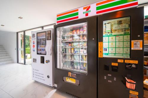 a drink vending machine in a store next to a drink cooler at 九雅集 The Nine Refined Retreats in Rawai Beach