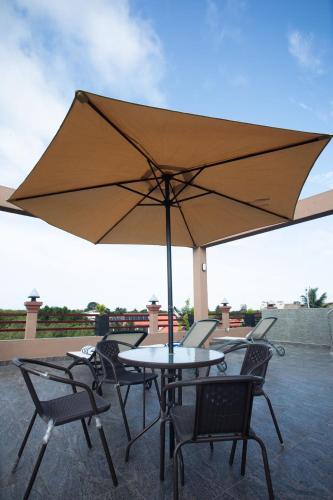 a table and chairs with an umbrella on a patio at Hotel Magdalina Lagoon in Negombo