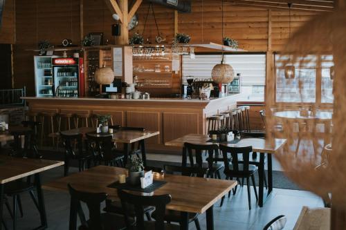 a restaurant with wooden tables and chairs and a bar at Hotel Central Vlašić in Vlasic