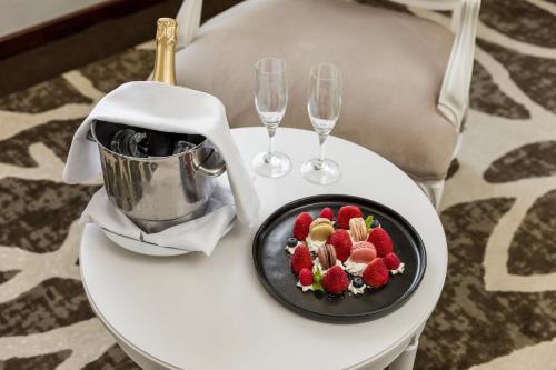 a plate of fruit on a table with wine glasses at Holiday Inn Porto Gaia by IHG in Vila Nova de Gaia