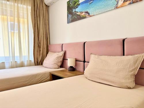 ein Hotelzimmer mit zwei Betten und einem Fenster in der Unterkunft City Charm Apartments 2 in Warna