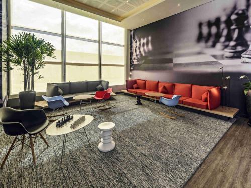 a living room with a red couch and chairs at ibis Jacarei in Jacareí