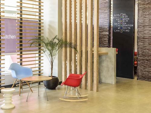 a room with chairs and a table and a plant at ibis Jacarei in Jacareí