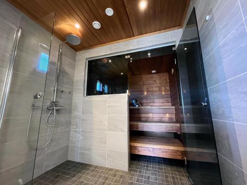 a bathroom with a shower with a glass door at Rantatähti Villa in Syöte