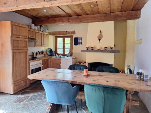 a kitchen with a wooden table and blue chairs at Rauft-Perfekter Rückzugsort für besondere Feierlichkeiten 2500 m2 Grundstück mitten in der Natur in Hasliberg
