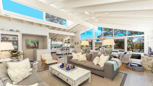 a large living room with couches and a table at 'Hampton Cottage' by HolidayCo in Pretty Beach