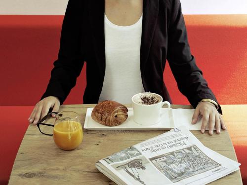 a person sitting at a table with a plate of food at ibis Guaiba in Guaíba