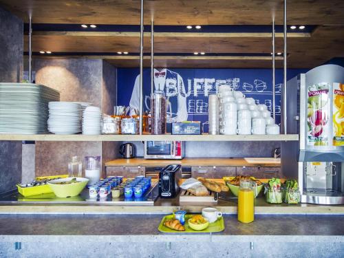 a kitchen with a counter with plates and food at ibis budget Troyes Est in Saint-Parres-aux-Tertres
