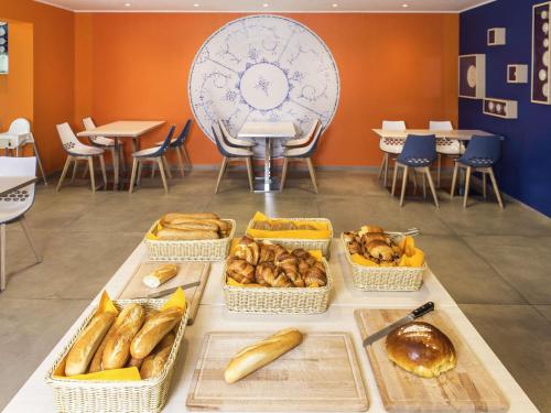 a table with baskets of bread and pastries on it at Ibis Styles La Louvière in La Louvière