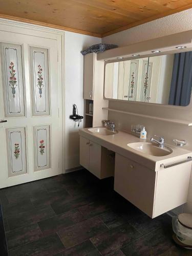 a bathroom with two sinks and a mirror at Parterre-Wohnung im Zentrum in Gstaad