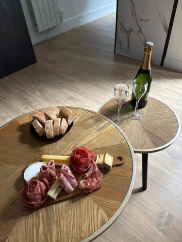 a table with a plate of food and a bottle of wine at CK Suite & Spa Reims in Reims