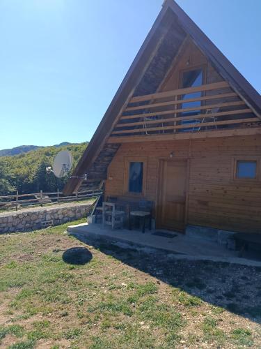 a log cabin with a porch and a satellite at Katun Mountain home in Žabljak