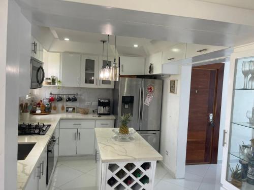 a kitchen with white cabinets and a stainless steel refrigerator at Penthouse apartment in La Grúa