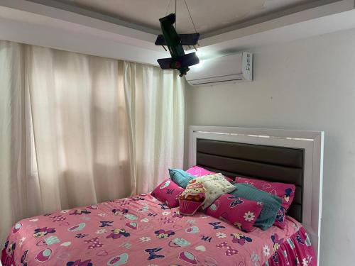 a bedroom with a pink bed with pink sheets and pillows at Penthouse apartment in La Grúa