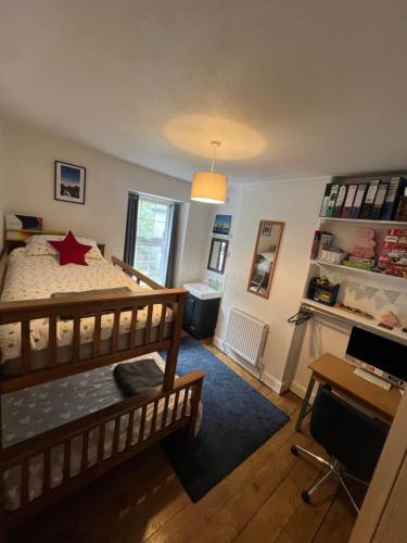 a bedroom with a bed and a desk with a computer at Bryn Y Gwynt, Betws y Coed in Betws-y-coed