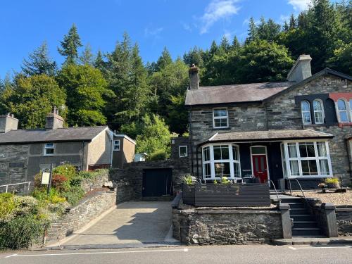 an old stone house with a red door at Bryn Y Gwynt, Betws y Coed in Betws-y-coed