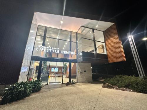 a large building with a sign on the front of it at Stylish four bedroom family retreat in Saltwater Coast in Point Cook