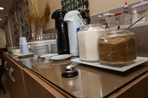 a counter with containers of food sitting on a counter top at Scenarium Hotel in Recife