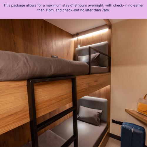 a bunk bed in a room with wooden walls at Sleepover - Lima Airport in Lima