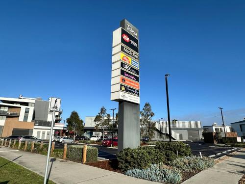 a pole with signs on it in a parking lot at Stylish four bedroom family retreat in Saltwater Coast in Point Cook
