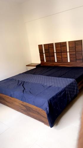 Un dormitorio con una cama con marco de madera. en Heavens appartment, en Karachi