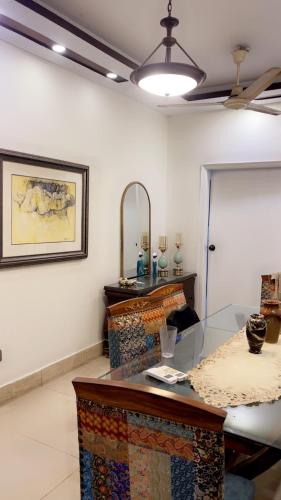 Habitación con mesa de cristal y espejo. en Heavens appartment, en Karachi