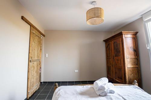 a bedroom with a bed and a wooden door at Gite à la ferme, authentique & accessible PMR 
