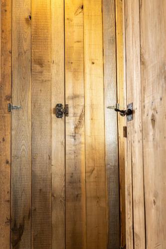 a wooden wall with two metal doors on it at Gite à la ferme, authentique & accessible PMR 