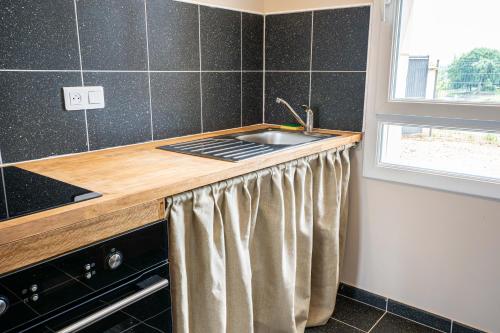 a kitchen counter with a sink and a window at Gite à la ferme, authentique & accessible PMR 