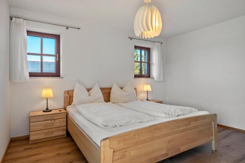 a bedroom with a bed with white sheets and two lamps at Wohnung Untersbergblick in Freilassing