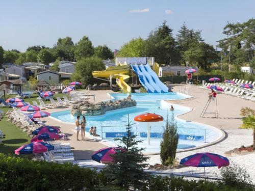 a pool with a water park with a slide at Mobil-home Elegance - 3 chambres in Seillac