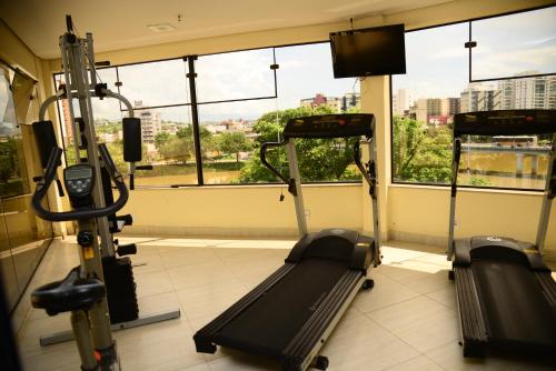 a gym with two tread machines in a room with windows at River Park Hotel in Resende