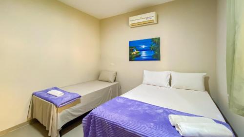 2 posti letto in una piccola camera con lenzuola viola di Residencial IL Pevero, condomínio com piscina e área gourmet a uma quadra da Praia de Taperapuã aptos com 2 quartos a Porto Seguro